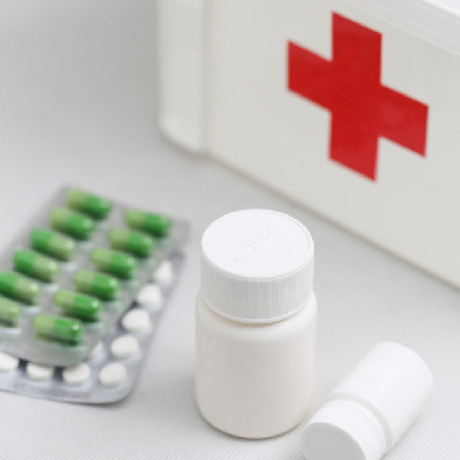 Medical kit with pills and first aid supplies.